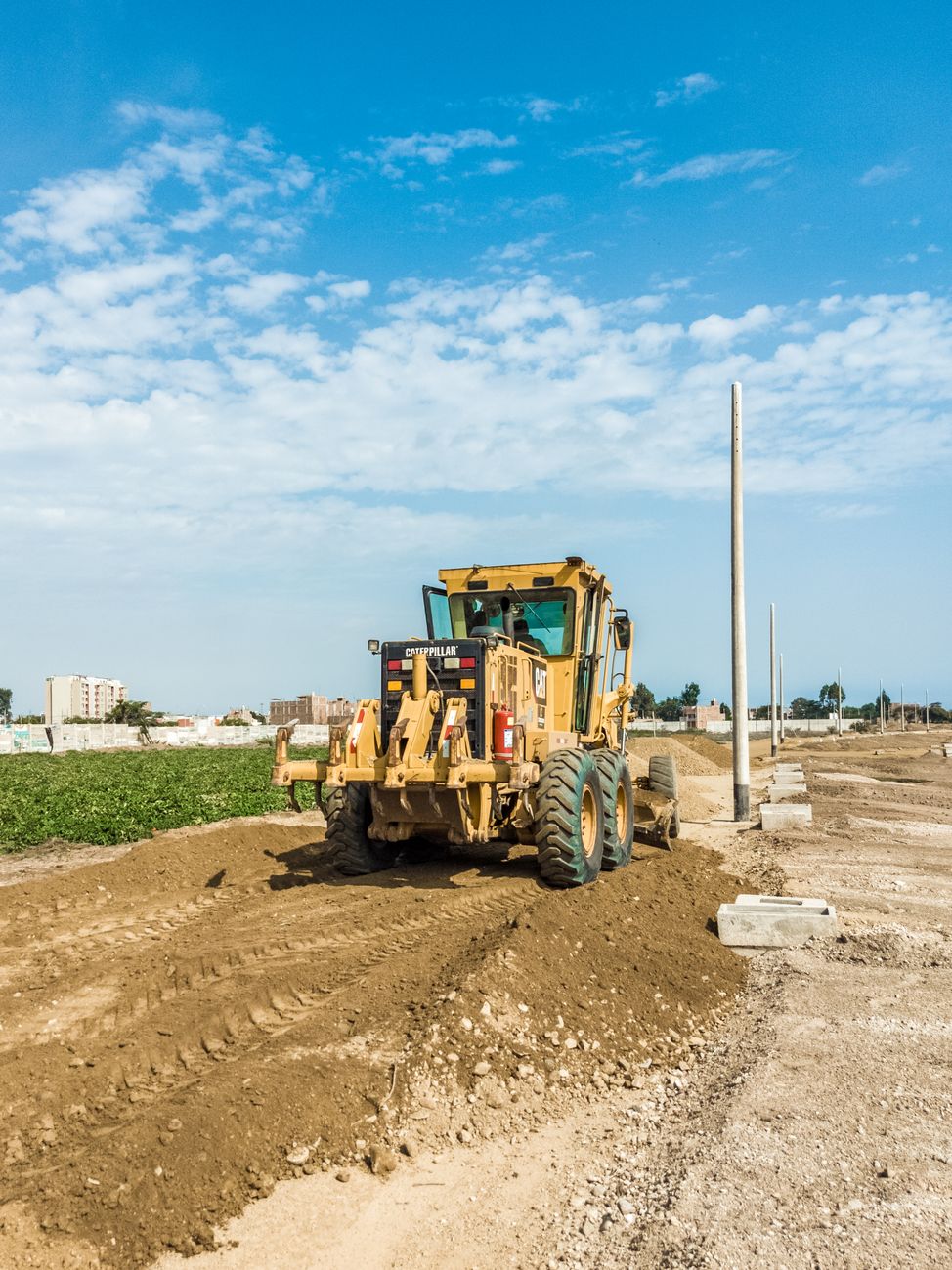 A powerful tractor working on a construction site under a bright blue sky, highlighting heavy engineering equipment.