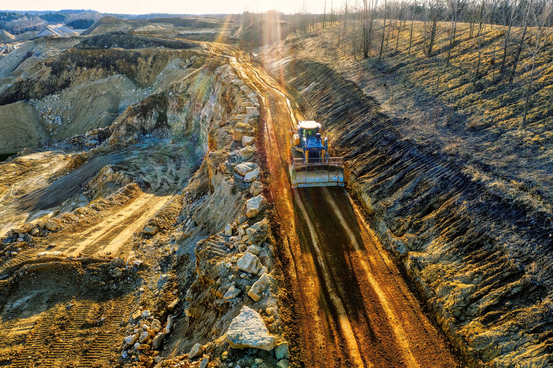 High-angle shot of a bulldozer on a rocky quarry path in Rochester, MN, during daytime.