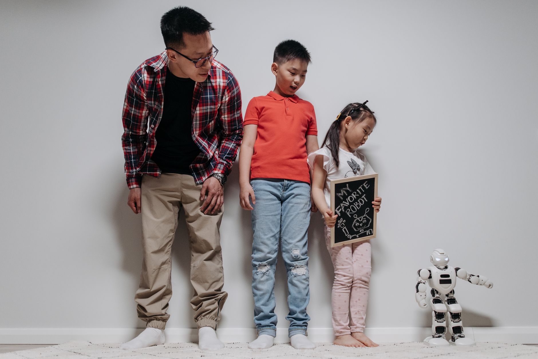 Father and children enjoying time with a robot toy at home, fostering bonding and exploration.